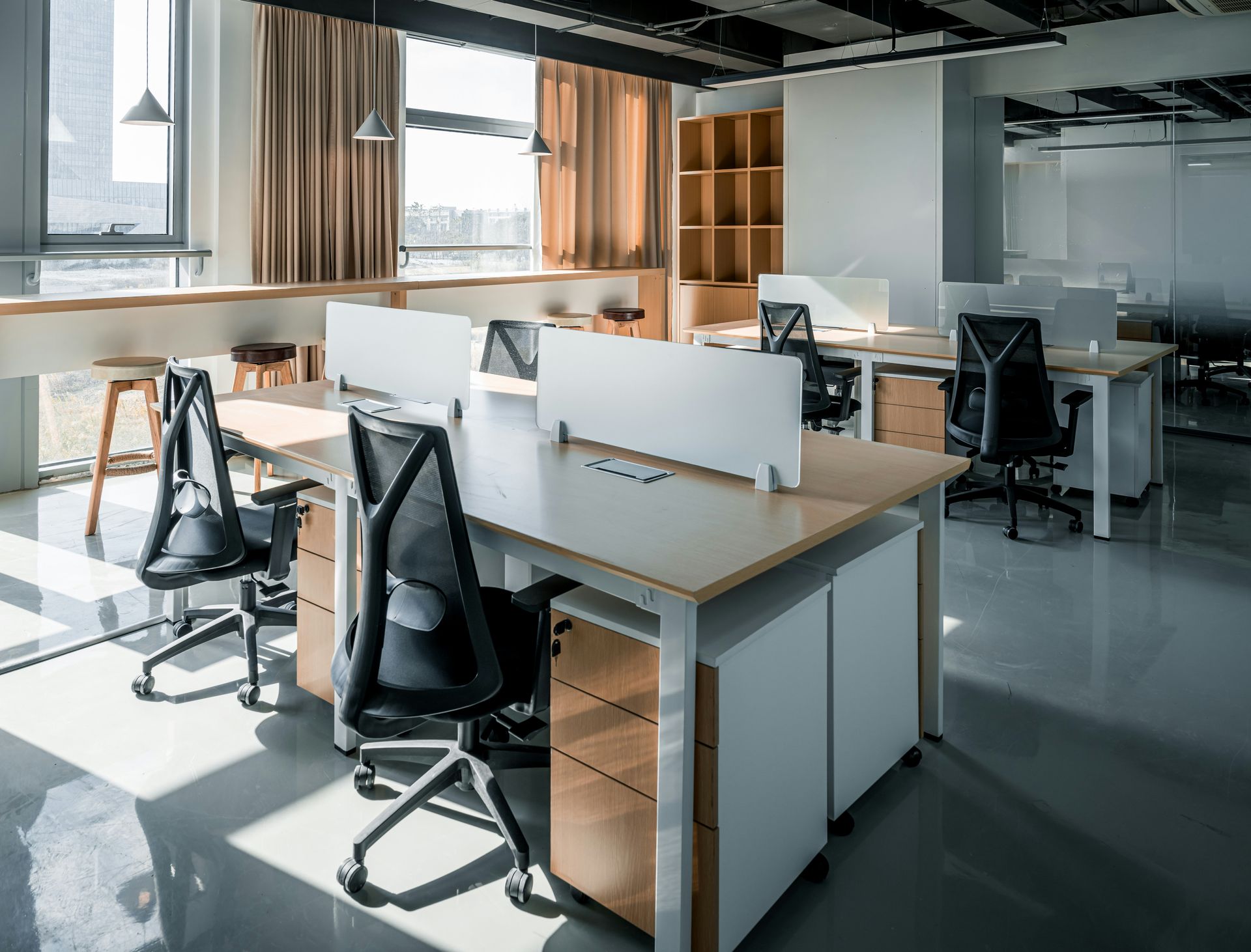 an office with a desk and chairs and a window